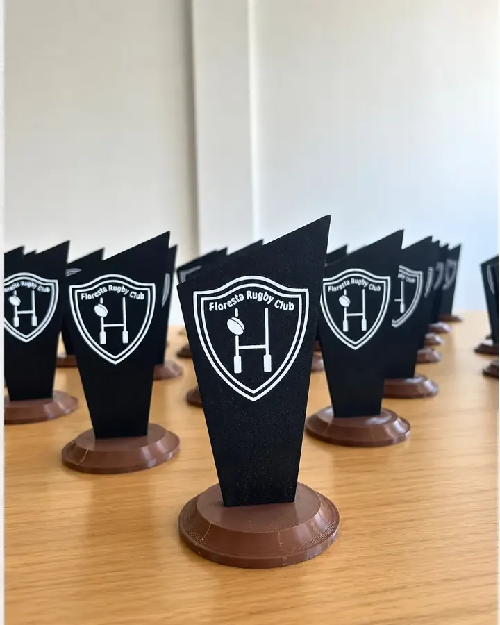 Serie de trofeos con escudo negro y base circular, fabricados con impresión 3D